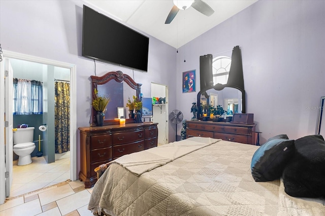 bedroom featuring ensuite bath, light tile patterned floors, ceiling fan, and vaulted ceiling