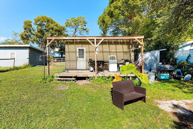 back of house featuring a wooden deck and a lawn