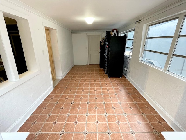 hallway featuring light tile patterned floors and crown molding