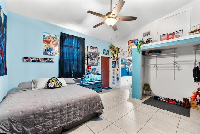 bedroom featuring ceiling fan, a closet, tile patterned floors, and lofted ceiling