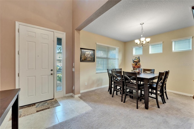 dining space featuring light carpet and an inviting chandelier