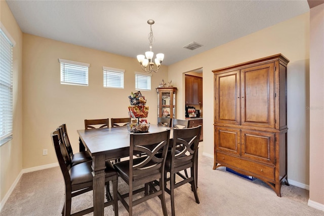 dining area featuring a notable chandelier and light carpet