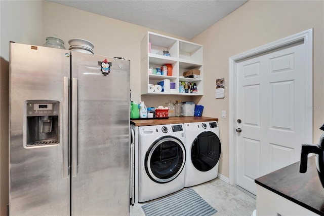 clothes washing area featuring washer and dryer and a textured ceiling