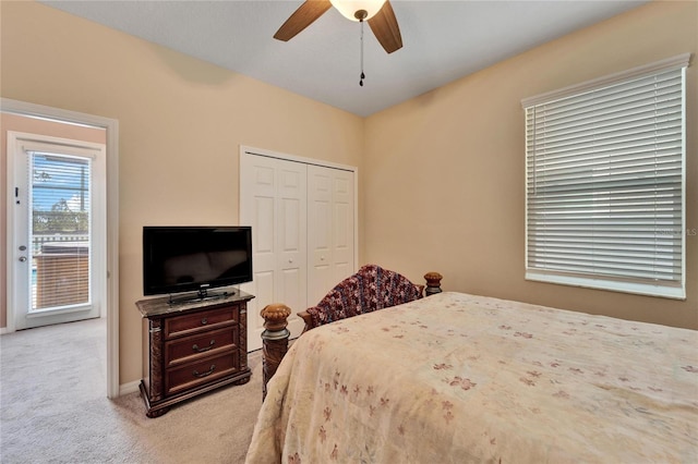 bedroom featuring ceiling fan, light carpet, and a closet