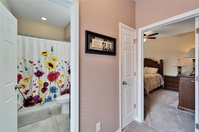 bathroom featuring shower / bath combo, toilet, and ceiling fan