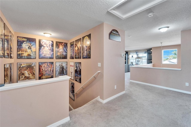 corridor featuring carpet floors and a textured ceiling