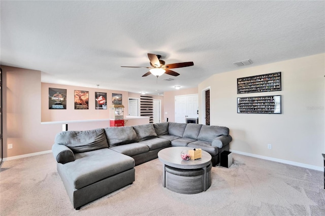 carpeted living room with a textured ceiling and ceiling fan