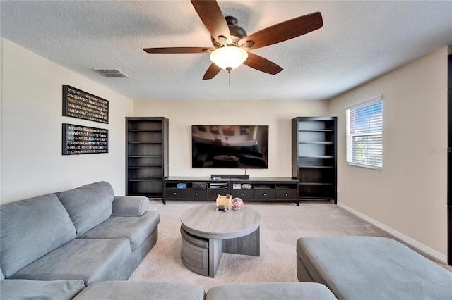 carpeted living room with a textured ceiling and ceiling fan