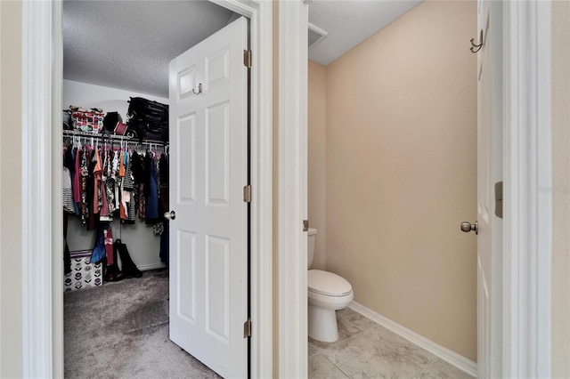 bathroom with toilet and a textured ceiling