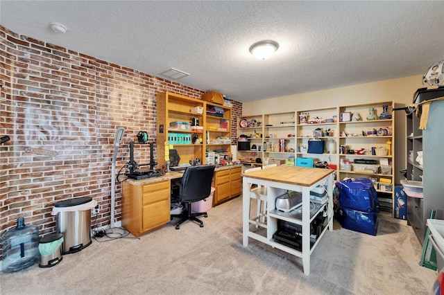 office space with light colored carpet, a textured ceiling, and brick wall