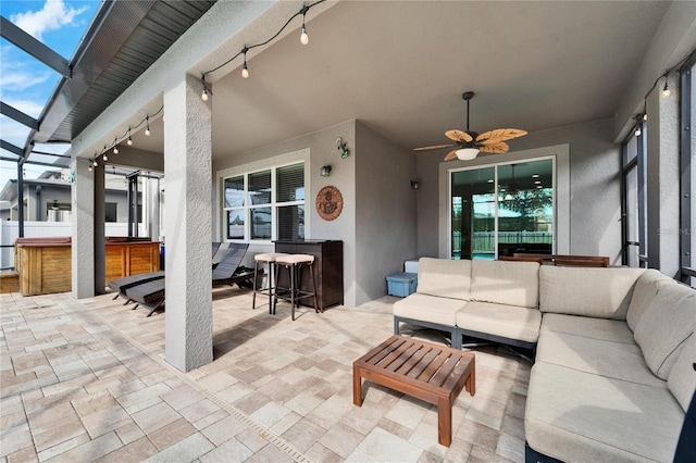 exterior space with exterior bar, outdoor lounge area, ceiling fan, glass enclosure, and a hot tub