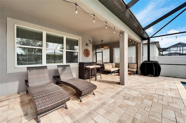 view of patio / terrace with glass enclosure, ceiling fan, and an outdoor hangout area