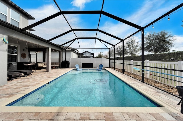 view of swimming pool with ceiling fan, a patio area, and a lanai