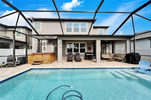 back of property featuring a lanai, a patio area, and a swimming pool with hot tub