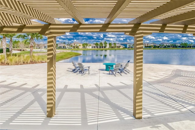 view of patio with a pergola and a water view