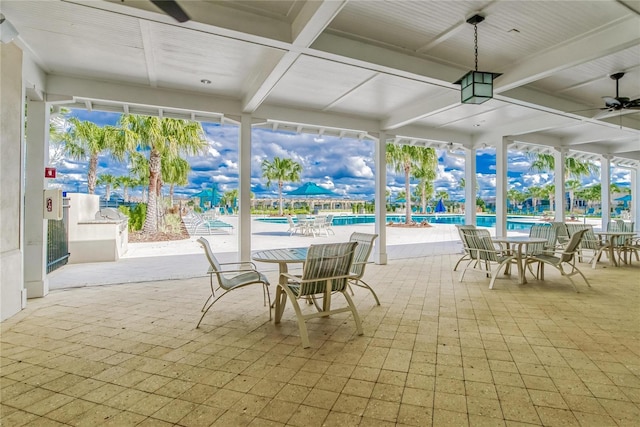 exterior space with beamed ceiling, ceiling fan, and coffered ceiling