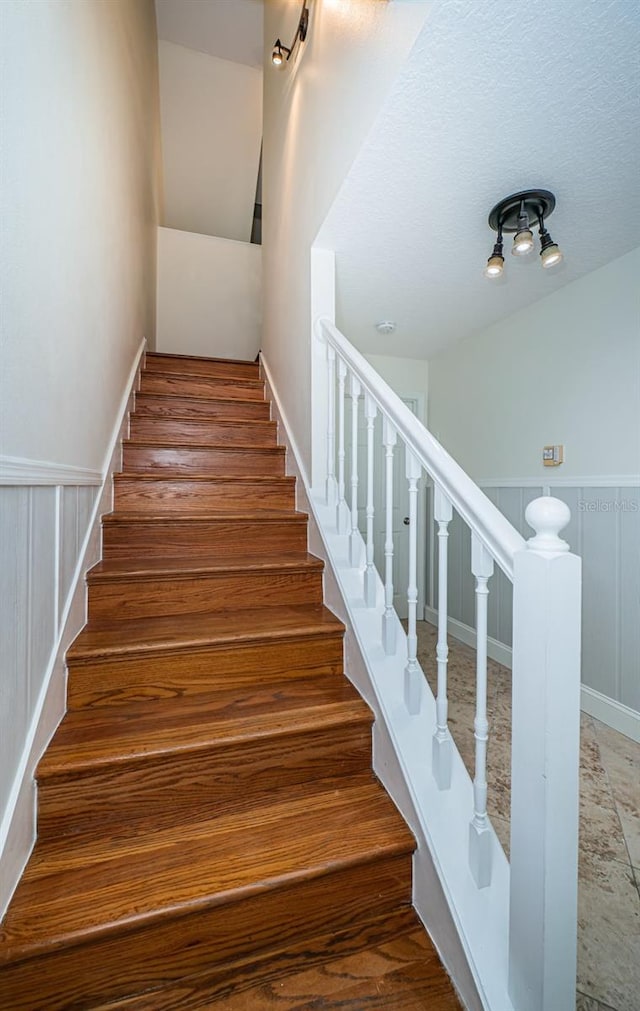 stairs featuring hardwood / wood-style flooring and a textured ceiling