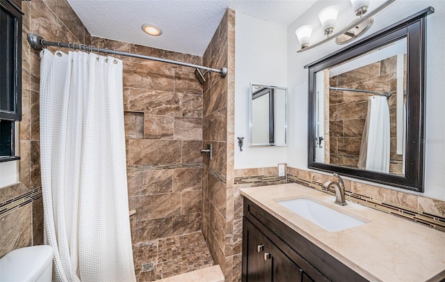 bathroom with a textured ceiling, toilet, walk in shower, and tile walls