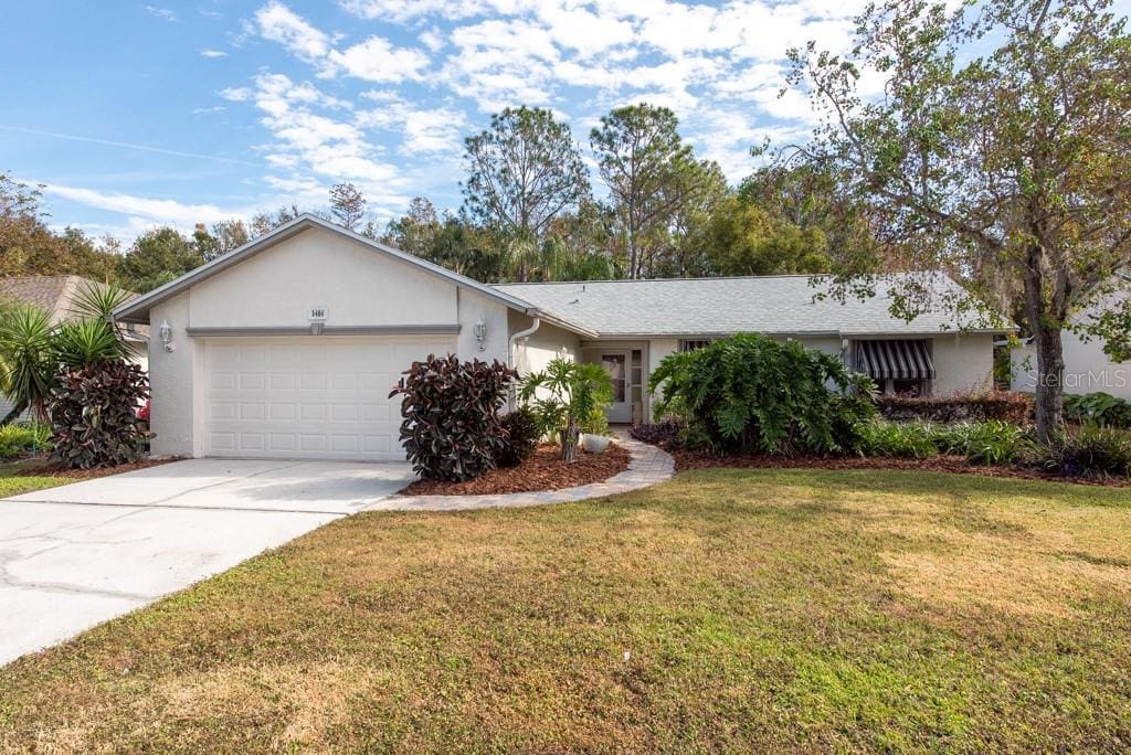 ranch-style home featuring a garage and a front lawn