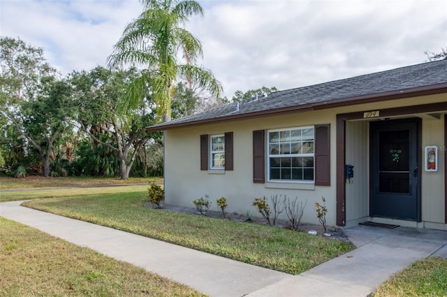 4215 E Bay Dr Unit 104, Clearwater, FL 33764 - property entrance featuring a lawn and roof with shingles