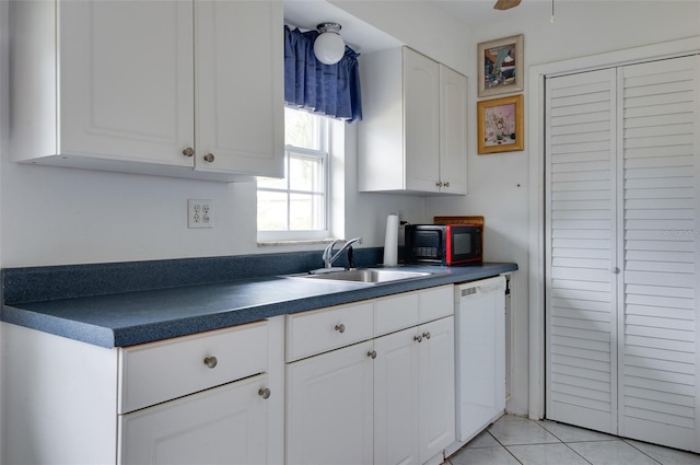 kitchen featuring dishwasher, sink, ceiling fan, light tile patterned flooring, and white cabinetry