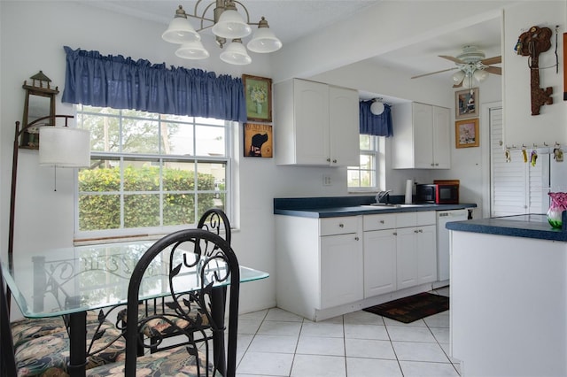 kitchen featuring ceiling fan with notable chandelier, sink, light tile patterned floors, dishwasher, and white cabinets