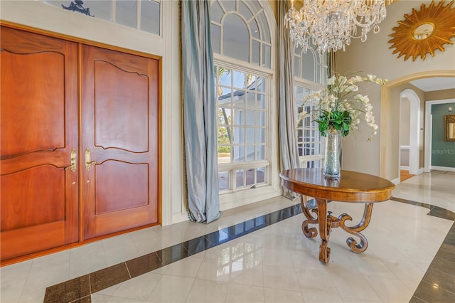 tiled foyer entrance with an inviting chandelier