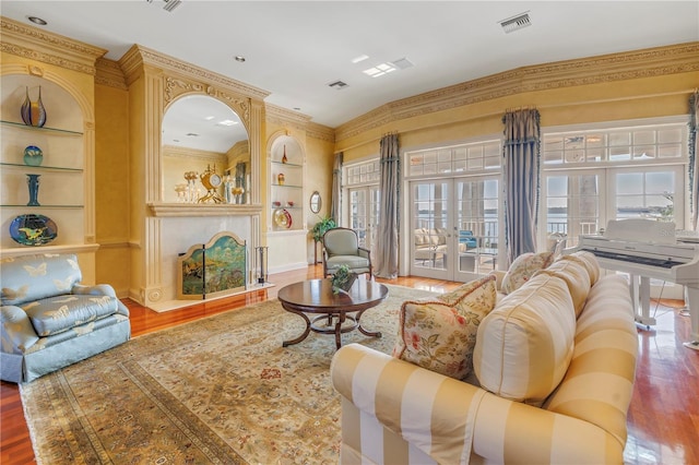 living room featuring built in shelves, french doors, and hardwood / wood-style floors