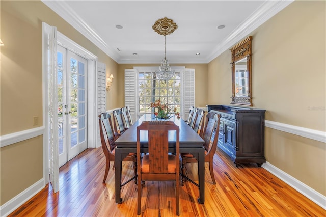 dining area with a wealth of natural light, french doors, ornamental molding, and light wood-type flooring