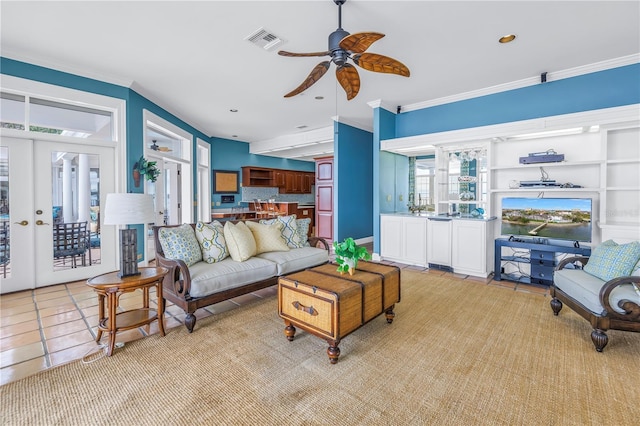 living room with french doors, light tile patterned floors, ceiling fan, and ornamental molding