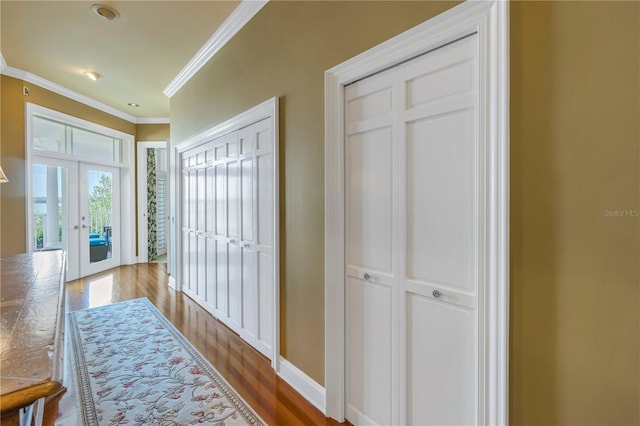 corridor featuring hardwood / wood-style flooring, ornamental molding, and french doors