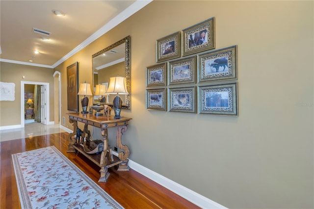 hall with hardwood / wood-style floors and ornamental molding