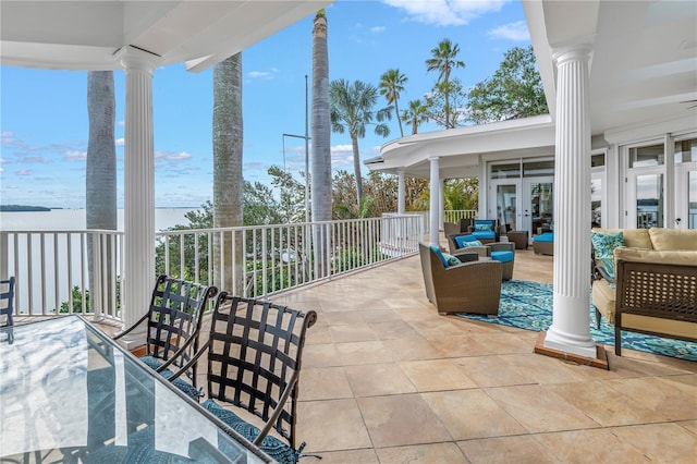 view of patio with an outdoor living space, a water view, and french doors