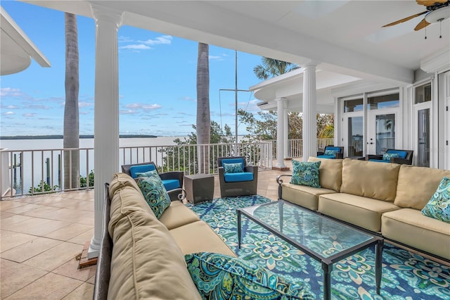 sunroom with a water view, ceiling fan, and a healthy amount of sunlight