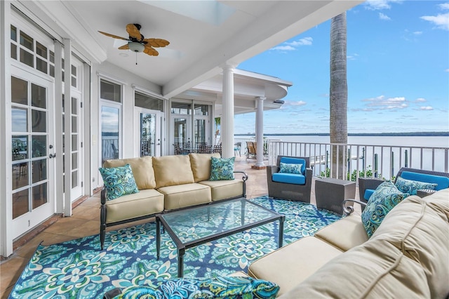 sunroom / solarium featuring a water view, ceiling fan, and a healthy amount of sunlight