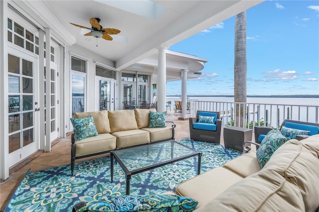 sunroom / solarium with french doors, a water view, plenty of natural light, and ceiling fan