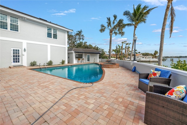 view of pool with a water view, a patio, and an in ground hot tub