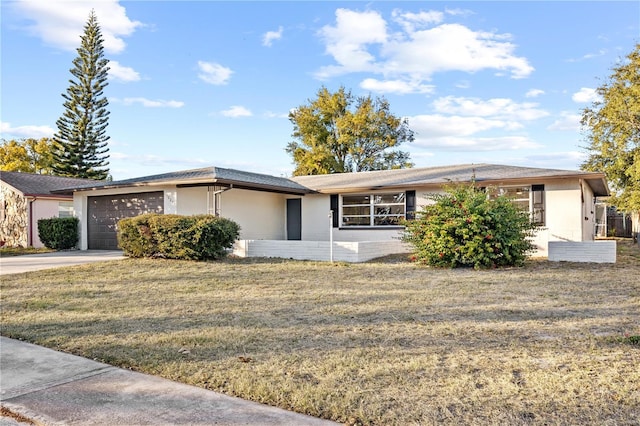 ranch-style home featuring a garage and a front lawn