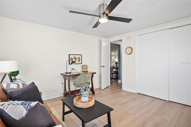 sitting room with a textured ceiling, light hardwood / wood-style flooring, and ceiling fan