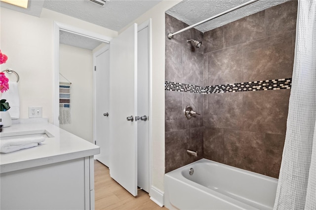 bathroom with hardwood / wood-style floors, shower / bath combination with curtain, a textured ceiling, and vanity