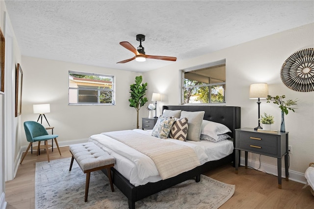 bedroom featuring ceiling fan, a textured ceiling, and hardwood / wood-style flooring