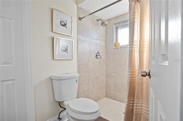 bathroom with toilet and a tile shower