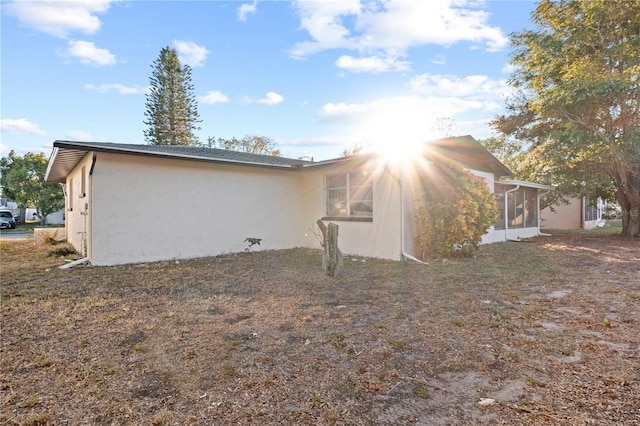 view of property exterior with a sunroom