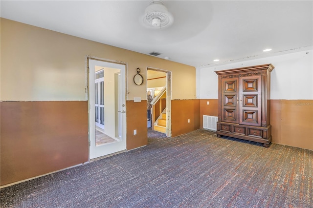 unfurnished room with dark colored carpet