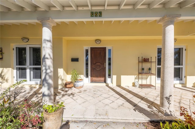 view of exterior entry featuring covered porch