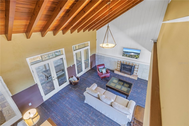 living room with french doors, wood ceiling, a high ceiling, and beam ceiling