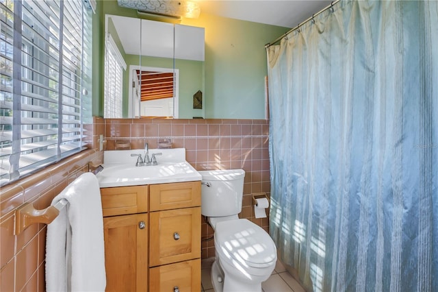 bathroom with vanity, tile patterned flooring, a shower with shower curtain, toilet, and tile walls