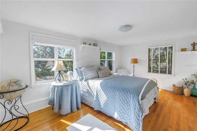 bedroom with light hardwood / wood-style floors and multiple windows