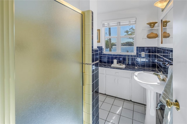 bathroom featuring tasteful backsplash, tile patterned flooring, a water view, and walk in shower