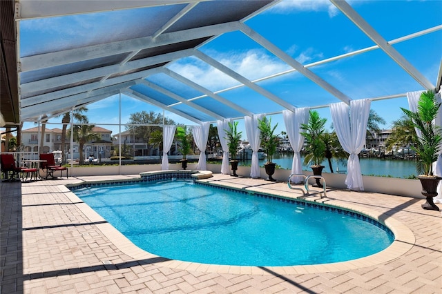 outdoor pool with a lanai, a water view, and a patio